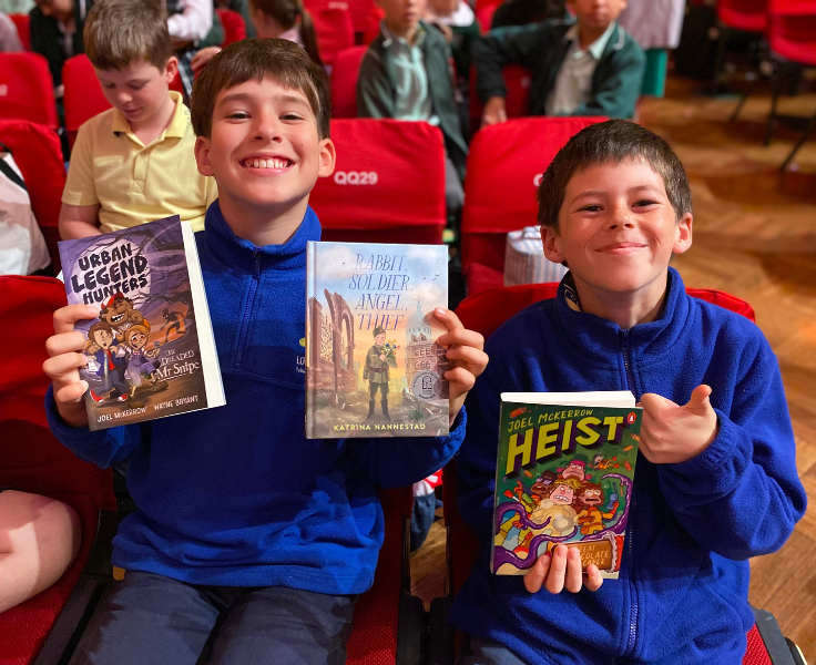 photo of 2 boys holding books