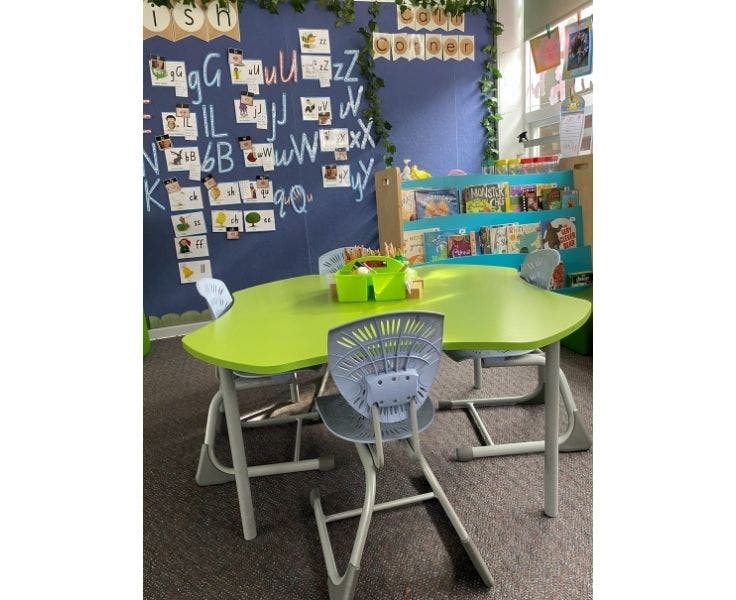 photo of a bright green table and student chairs in a classroom