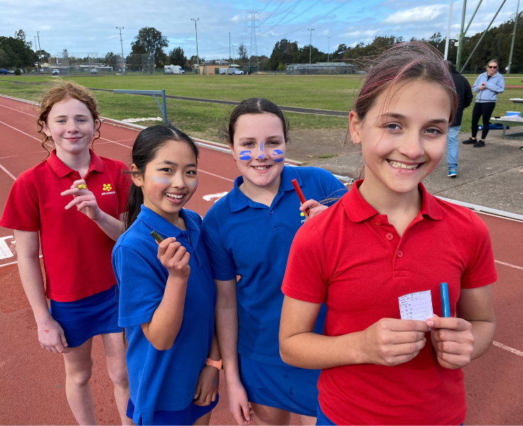 photo of 4 students holding place markers after a running race