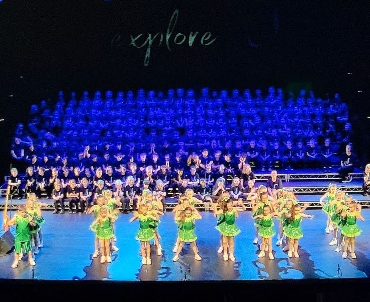 Photo of dancers on stage and choir in the background